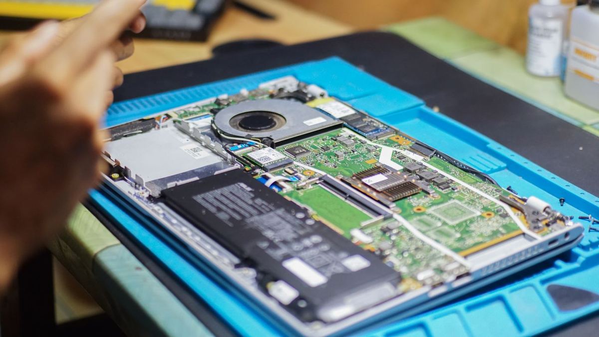 Computer portatile aperto sul banco con i componenti a vista durante la riparazione